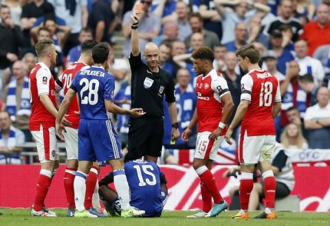 Referee Anthony Taylor, center, sends off Chelsea's Victor Moses, on the ground, after showing him a second yellow card during the English FA Cup final soccer match between Arsenal and Chelsea at Wembley stadium in London, Saturday, May 27, 2017. (AP Photo/Kirsty Wigglesworth)