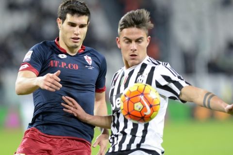 Juventus' Paulo Dybala, right, challenges for the ball with Genoa' Ezuquiel Munoz during a Serie A soccer match at the Juventus stadium, in Turin, Italy, Wednesday, Feb. 3, 2016. (AP Photo/Massimo Pinca)