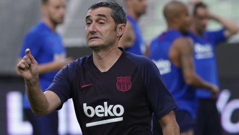 FC Barcelona's head coach Ernesto Valverde gestures as players of FC Barcelona warm up during a training session at Noevir Stadium in Kobe, western Japan Friday, July 26, 2019. FC Barcelona and Japan's Vissel Kobe will meet at a friendly soccer match on July 27. (AP Photo/Eugene Hoshiko)