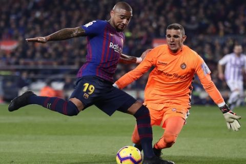 FC Barcelona's Kevin-Prince Boateng, left, duels for the ball with Valladolid's goalkeeper Jordi Masip during the Spanish La Liga soccer match between FC Barcelona and Valladolid at the Camp Nou stadium in Barcelona, Spain, Saturday, Feb. 16, 2019. (AP Photo/Manu Fernandez)