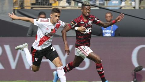 Lucas Martinez Quarta of Argentina's River Plate, left, fights for the ball with Bruno Henrique of Brazil's Flamengo during the Copa Libertadores final soccer match at the Monumental stadium in Lima, Peru, Saturday, Nov. 23, 2019. (AP Photo/Martin Mejia)