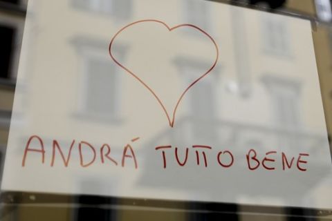 A note reading in Italian ' Everything will go fine ', hangs on the window of a shop in Milan, Italy, Wednesday, March 11, 2020. Italy is mulling even tighter restrictions on daily life and has announced billions in financial relief to cushion economic shocks from the coronavirus. For most people, the new coronavirus causes only mild or moderate symptoms, such as fever and cough. For some, especially older adults and people with existing health problems, it can cause more severe illness, including pneumonia. (AP Photo/Luca Bruno)