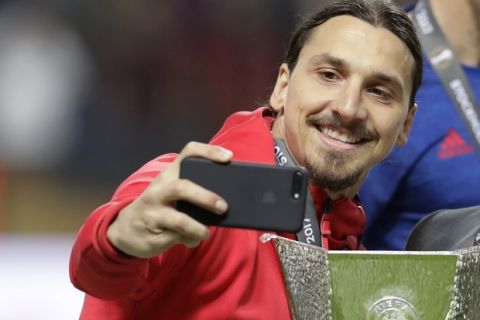 Manchester's injured player Zlatan Ibrahimovic takes a selfie after winning 2-0 during the soccer Europa League final between Ajax Amsterdam and Manchester United at the Friends Arena in Stockholm, Sweden, Wednesday, May 24, 2017. (AP Photo/Michael Sohn)
