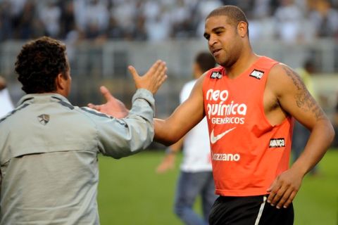 Corinthians player Adriano (R) celebrates the victory of his team in the Brazilian Championship after tying by 0-0 in their final date match against Palmeiras, at the Pacaembu stadium on December 04, 2011 in Sao Paulo, Brazil. AFP PHOTO / Nelson ALMEIDA (Photo credit should read NELSON ALMEIDA/AFP/Getty Images)
