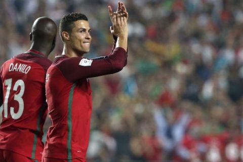 Portugal's Cristiano Ronaldo, right, and Danilo celebrate at the end of the World Cup Group B qualifying soccer match between Portugal and Switzerland at the Luz stadium in Lisbon, Tuesday, Oct. 10, 2017. (AP Photo/Armando Franca)