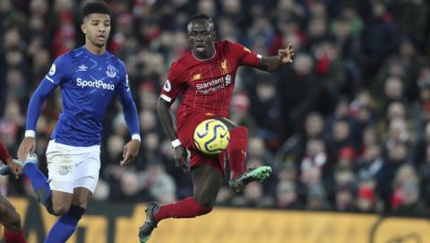 Liverpool's Sadio Mane, right, controlls the ball by Everton's Mason Holgate during the English Premier League soccer match between Liverpool and Everton at Anfield Stadium, Liverpool, England, Wednesday, Dec. 4, 2019. (AP Photo/Jon Super)