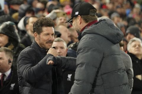 Atletico Madrid's head coach Diego Simone, left, and Liverpool's manager Jurgen Klopp greet each other prior a second leg, round of 16, Champions League soccer match between Liverpool and Atletico Madrid at Anfield stadium in Liverpool, England, Wednesday, March 11, 2020. (AP Photo/Jon Super)