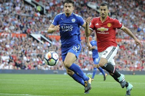 Manchester United's Henrikh Mkhitaryan, right, challenges Leicester's Harry Maguire, left, during the English Premier League soccer match between Manchester United and Leicester City at Old Trafford in Manchester, England, Saturday, Aug. 26, 2017. (AP Photo/Rui Vieira)