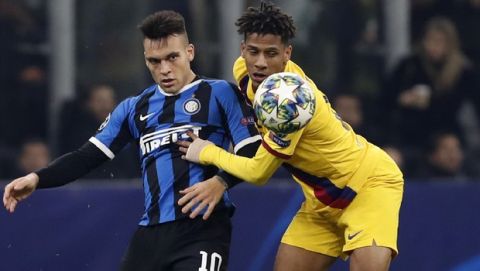 Inter Milan's Lautaro Martinez, left, duels for the ball with Barcelona's Jean-Clair Todibo during the Champions League group F soccer match between Inter Milan and Barcelona at the San Siro stadium in Milan, Italy, Tuesday, Dec. 10, 2019. (AP Photo/Antonio Calanni)
