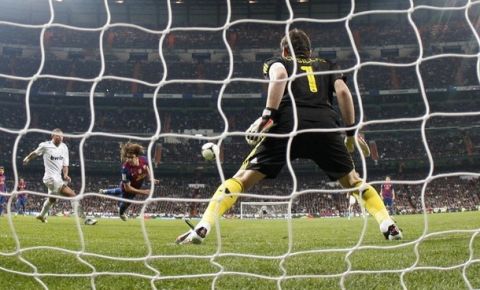 Barcelona's Carles Puyol (C) scores his goal against Real Madrid's goalkeeper Iker Casillas (R) during their Spanish King's Cup quarter-final first leg "El Clasico" soccer match at the Santiago Bernabeu stadium in Madrid January 18, 2012.       REUTERS/Sergio Perez (SPAIN - Tags: SPORT SOCCER)