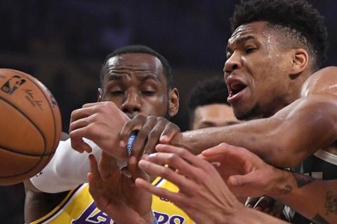 Los Angeles Lakers forward LeBron James, left, knocks the ball from the hands of Milwaukee Bucks forward Giannis Antetokounmpo during the first half of an NBA basketball game Friday, March 6, 2020, in Los Angeles. (AP Photo/Mark J. Terrill)