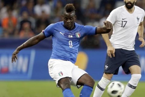 Italy's Mario Balotelli, left, kicks the ball while France's Edil Rami looks on during a friendly soccer match between France and Italy at the Allianz Riviera stadium in Nice, southern France, Friday, June 1, 2018. (AP Photo/Claude Paris)