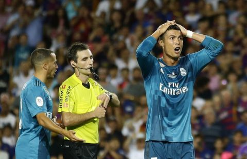 Real Madrid's Cristiano Ronaldo, right, reacts after Referee Ricardo de Burgos shows a yellow card during the Spanish Supercup, first leg, soccer match between FC Barcelona and Real Madrid at the Camp Nou stadium in Barcelona, Spain, Sunday, Aug. 13, 2017. (AP Photo/Manu Fernandez)
