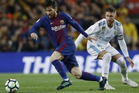 Barcelona's Lionel Messi, left, steers the ball past Real Madrid's Sergio Ramos during a Spanish La Liga soccer match between Barcelona and Real Madrid, dubbed 'el clasico', at the Camp Nou stadium in Barcelona, Spain, Sunday, May 6, 2018. (AP Photo/Manu Fernandez)