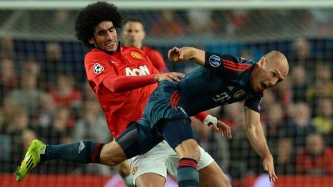 Bayern Munich's Dutch midfielder Arjen Robben (R) is tackled by Manchester United's Belgian midfielder Marouane Fellaini (L) during the UEFA Champions League quarter-final first leg football match between Manchester United and Bayern Munich at Old Trafford in Manchester on April 1, 2014.  AFP PHOTO / ANDREW YATES        (Photo credit should read ANDREW YATES/AFP/Getty Images)