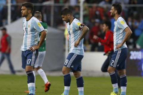 Argentina's Matias Caruzzo, left, Ever Vanegas, center, and Mateo Musacchio leave the field at the end of a 2018 Russia World Cup qualifying soccer match against Bolivia, at the Hernando Siles stadium in La Paz, Bolivia, Tuesday, March 28, 2017. Bolivia won 2-0. (AP Photo/Juan Karita)