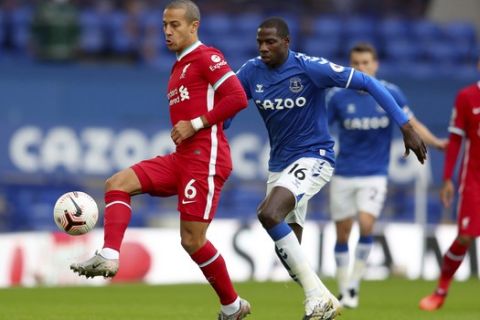 Liverpool's Thiago, left, competes for the ball with Everton's Abdoulaye Doucoure during the English Premier League soccer match between Everton and Liverpool at Goodison Park stadium, in Liverpool, England, Saturday, Oct. 17, 2020. (Cath Ivill/Pool via AP)