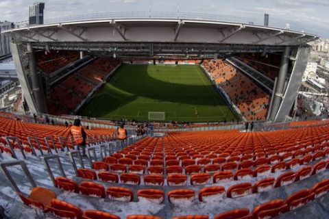 In this photo taken on Sunday, April 1, 2018, people watch from the stands of the new World Cup stadium in Yekaterinburg during the Russian premier league soccer match between Ural Yekaterinburg and Rubin Kazan in Russia. The stadium will hold four group-stage games at the World Cup, and will be reduced to around 35,000 seats after the tournament by removing temporary stands.(AP Photo/Anton Basanaev)
