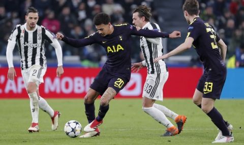 Tottenham's Dele Alli, 2nd left, is challenged by Juventus' Federico Bernardeschi during the Champions League, round of 16, first-leg soccer match between Juventus and Tottenham Hotspurs, at the Allianz Stadium in Turin, Italy, Tuesday, Feb. 13, 2018. (AP Photo/Antonio Calanni)