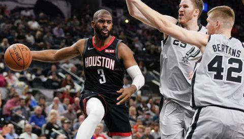 Houston Rockets' Chris Paul (3) looks to pass the ball as San Antonio Spurs' Davis Bertans (42) and Jakob Poeltl defend during the first half of an NBA basketball game Friday, Nov. 30, 2018, in San Antonio. (AP Photo/Darren Abate)
