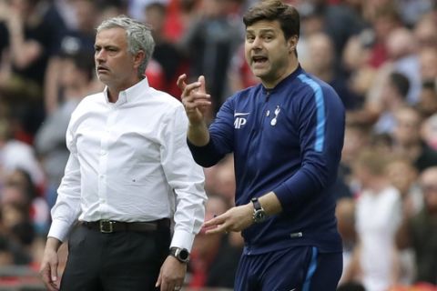 Tottenham manager Mauricio Pochettino gestures next to Manchester United manager Jose Mourinho, left, during the English FA Cup semifinal soccer match between Manchester United and Tottenham Hotspur at Wembley stadium in London, Saturday, April 21, 2018. (AP Photo/Kirsty Wigglesworth)