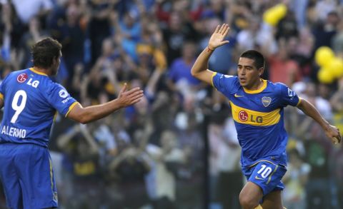 Boca Juniors midfielder Juan Roman Riquelme (R) celebrates with his teammate forward Martin Palermo after scoring a goal against Estudiantes during the Argentina First Division football match, at La Bombonera stadium in Buenos Aires, on April 3, 2011.  AFP PHOTO / Alejandro PAGNI