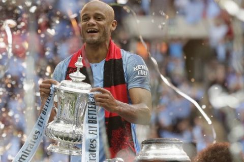 Manchester City's team captain Vincent Kompany lifts the trophy after winning the English FA Cup Final soccer match between Manchester City and Watford at Wembley stadium in London, Saturday, May 18, 2019. Manchester City won 6-0. (AP Photo/Tim Ireland)