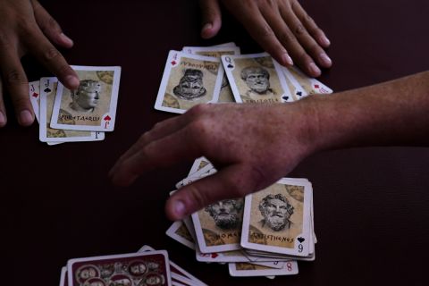 Men pass the time playing cards a shelter for migrants Thursday, April 21, 2022, in Tijuana, Mexico. A critical Trump-era policy that forces asylum-seekers to wait in Mexico for hearings in U.S. immigration court will be argued Tuesday before the U.S. Supreme Court. (AP Photo/Gregory Bull)