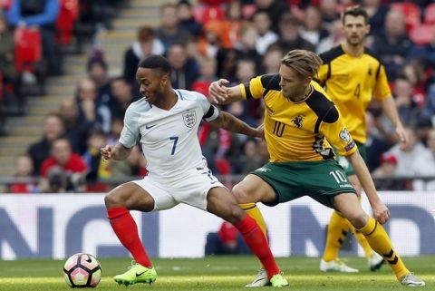 England's Raheem Sterling, left, and Lithuania's Aturas Zulpa, right, challenge for the ball during the World Cup Group F qualifying soccer match between England and Lithuania at the Wembley Stadium in London, Great Britain, Sunday, March 26, 2017. (AP Photo/Kirsty Wigglesworth)