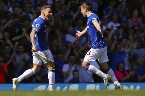 Everton's Lucas Digne, left, celebrates scoring against Manchester United with teammate Seamus Coleman during the English Premier League soccer match at Goodison Park, Liverpool, England, Sunday April 21, 2019. (Martin Rickett/PA via AP)