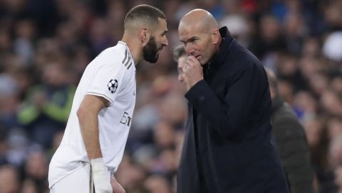 Real Madrid's head coach Zinedine Zidane, right, speaks with Karim Benzema during a Champions League group A soccer match between Real Madrid and Galatasaray at the Santiago Bernabeu stadium in Madrid, Spain, Wednesday, Nov. 6, 2019. (AP Photo/Manu Fernandez)