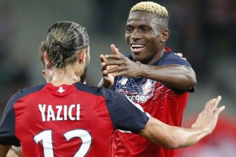 Lille's Victor Osimhen, right, celebrates after scoring during the French league one soccer match between Lille and Strasbourg in Villeneuve d'Ascq, Wednesday Sept 25, 2019. (AP Photo/Michel Spingler)