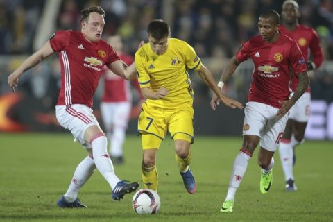 Manchester United's Phil Jones, left, Manchester United's Ashley Young, right, and Rostov's Dmitri Poloz fight for the ball during the Europa League round of 16 first leg soccer match between Rostov and Manchester United in Rostov-on-Don, Russia, Thursday, March 9, 2017. (AP Photo/Denis Tyrin)
