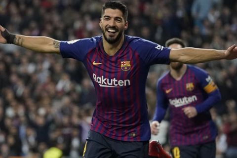 Barcelona forward Luis Suarez celebrates after Real defender Raphael Varane scores an own goal during the Copa del Rey semifinal second leg soccer match between Real Madrid and FC Barcelona at the Bernabeu stadium in Madrid, Spain, Wednesday Feb. 27, 2019. (AP Photo/Andrea Comas)