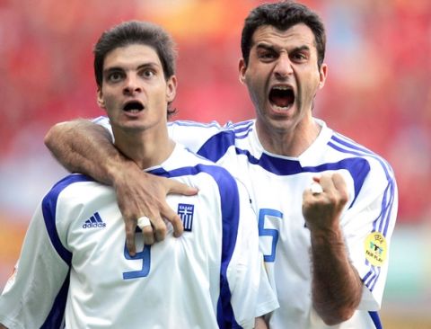 Greece's forward Angelos Charisteas (L) celebrates with his teammate, defender Traianos Dellas after scoring the equaliser goal, 16 June 2004 at Bessa stadium in Porto, during their Euro 2004 group A football match against Spain at the European Nations championship in Portugal. AFP PHOTO Javier SORIANO