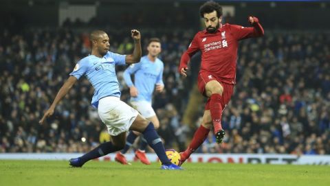 Manchester City's Fernandinho, left, is challenged by Liverpool's Mohamed Salah during their English Premier League soccer match between Manchester City and Liverpool at the Ethiad stadium, Manchester England, Thursday, Jan. 3, 2019. (AP Photo/Jon Super)
