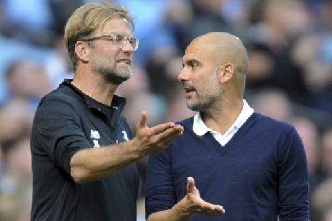Manchester City's coach Pep Guardiola, right, and Liverpool's coach Juergen Klopp, left, talk during the English Premier League soccer match between Manchester City and Liverpool at the Etihad Stadium in Manchester, England, Saturday, Sept. 9, 2017. (AP Photo/Rui Vieira)
