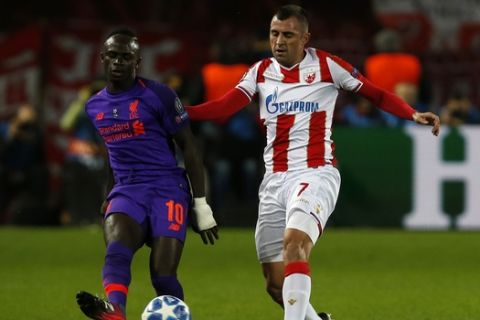 Liverpool midfielder Sadio Mane, left, passes as Red Star's Nenad Krsticic defends during the Champions League group C soccer match between Red Star and Liverpool at Rajko Mitic stadium in Belgrade, Tuesday, Nov. 6, 2018. (AP Photo/Darko Vojinovic)