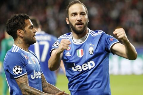 Juventus' Gonzalo Higuain, right, celebrates with his teammate Dani Alves after scoring during the Champions League semifinal first leg soccer match between Monaco and Juventus at the Louis II stadium in Monaco, Wednesday, May 3, 2017. (AP Photo/Claude Paris)