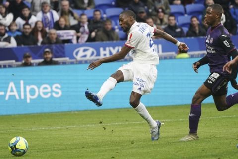 Lyon's Karl Toko Ekambi, center, scores his side's third goal during the French League One soccer match between Lyon and Toulouse in Decines, outside Lyon, central France, Sunday, Jan. 26, 2020. (AP Photo/Laurent Cipriani)