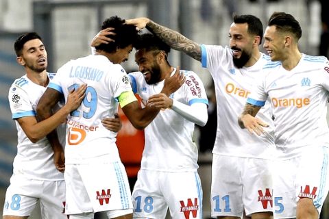 Marseille's players celebrate after Marseille's Luiz Gustavo Dias, second left, scored during the League One soccer match between Marseille and Caen, at the Velodrome stadium, in Marseille, southern France, Sunday, Nov. 5, 2017. (AP Photo/Claude Paris)