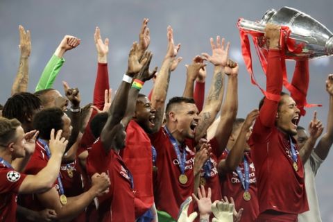Liverpool's Virgil van Dijk lifts the trophy as celebrates with his teammates after winning the Champions League final soccer match between Tottenham Hotspur and Liverpool at the Wanda Metropolitano Stadium in Madrid, Sunday, June 2, 2019. Liverpool won 2-0. (AP Photo/Felipe Dana)