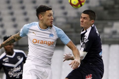 Marseille's Lucas Ocampos, left, and Bordeaux Jules Kunde vie to head the ball during the French League One soccer match between Olympique Marseille and Bordeaux At Velodrome Stadium, in Marseille, Tuesday, Feb. 5, 2019. (AP Photo/Claude Paris)