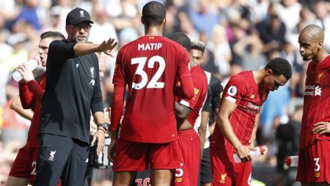 Liverpool's manager Jurgen Klopp, left, talks to his players during the English Premier League soccer match between Liverpool and Newcastle at Anfield stadium in Liverpool, England, Saturday, Sept. 14, 2019. (AP Photo/Rui Vieira)