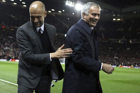 FILE - In this Wednesday, Oct. 26, 2016 file photo, Manchester City's manager Pep Guardiola, left, and Manchester United's manager Jose Mourinho smile ahead of their English League Cup soccer match at Old Trafford stadium in Manchester. There were handshakes, smiles, even an embrace, in the first two head-to-heads between Pep Guardiola and Jose Mourinho in English soccer. With the pressure and tension ramped up a notch for the third Manchester derby of the season, will the two coaching adversaries be able to retain their new-found cordiality on Thursday, April 27? (AP Photo/Dave Thompson, file)