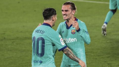 Barcelona's Antoine Griezmann, right, is congratulated by teammate Lionel Messi after scoring his side third goal during the Spanish La Liga soccer match between FC Barcelona and Villareal at La Ceramica stadium in Villareal, Spain, Sunday, July 5, 2020. (AP Photo/Jose Miguel Fernandez)