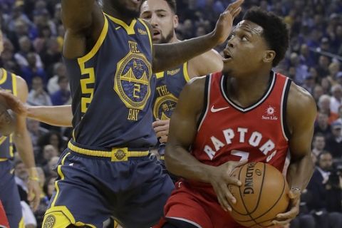 Toronto Raptors guard Kyle Lowry, right, is defended by Golden State Warriors forward Jordan Bell (2) during the first half of an NBA basketball game in Oakland, Calif., Wednesday, Dec. 12, 2018. (AP Photo/Jeff Chiu)