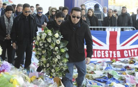 Aiyawatt Srivaddhanaprabha, the son of Vichai Srivaddhanaprabha, and his mother Aimon, center left, lay a wreath with family members outside Leicester City Football Club, Leicester, England, Monday Oct. 29, 2018, after a helicopter crashed in flames Saturday. Vichai Srivaddhanaprabha, the Thai billionaire owner of Premier League team Leicester City was among five people who died after his helicopter crashed and burst into flames shortly after taking off from the soccer field, the club said Sunday. (AP Photo/Rui Vieira)