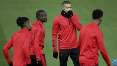 Paris Saint Germain's Kylian Mbappe , second right talks with teammates, during a training session at Old Trafford, in Manchester, England, Monday, Feb. 11, 2019. Paris Saint Germain will play Manchester United in a Champions League Round of 16 soccer match on Tuesday. (Martin Rickett/PA via AP)