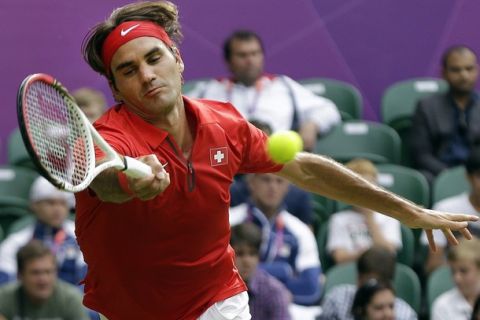 Roger Federer of Switzerland returns to Alejandro Falla of Colombia during a first round match at the All England Lawn Tennis Club in Wimbledon, London at the 2012 Summer Olympics, Saturday, July 28, 2012. (AP Photo/Elise Amendola)